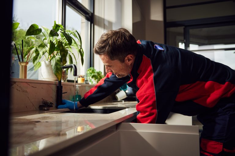 Pimlico plumber repairing kitchen tap